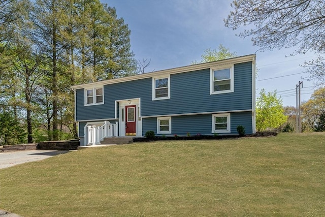 split foyer home featuring driveway and a front lawn