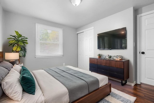 bedroom featuring a closet, dark wood finished floors, and baseboards