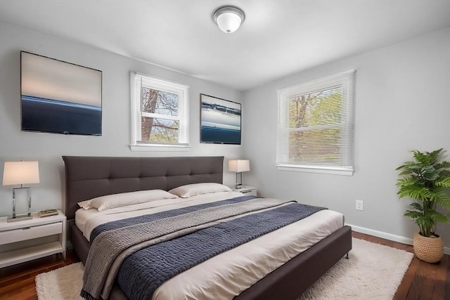 bedroom featuring baseboards and dark wood-style flooring