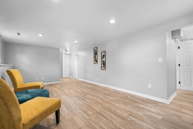 sitting room with baseboards, recessed lighting, and light wood-type flooring