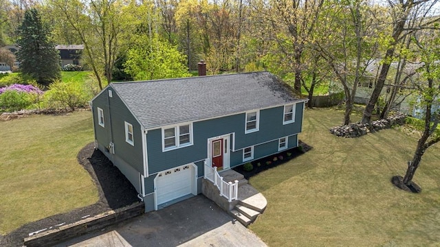 view of front of house featuring a garage, a front lawn, driveway, and roof with shingles