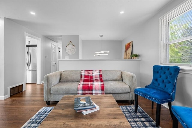 living room with visible vents, an inviting chandelier, wood finished floors, baseboards, and recessed lighting