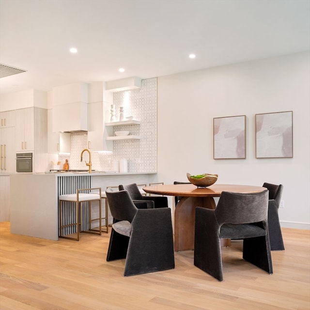 dining space featuring light wood-type flooring and sink