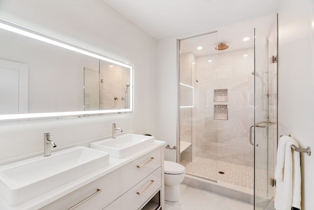 bathroom featuring tile patterned flooring, vanity, a shower with door, and toilet