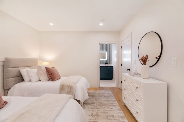 bedroom with light hardwood / wood-style flooring and ensuite bath