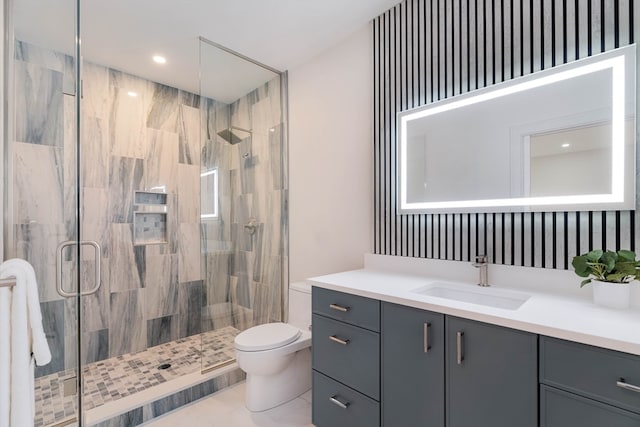 bathroom featuring tile patterned flooring, toilet, walk in shower, and vanity