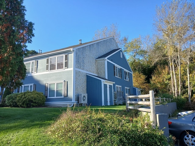 view of side of property with ac unit and a yard