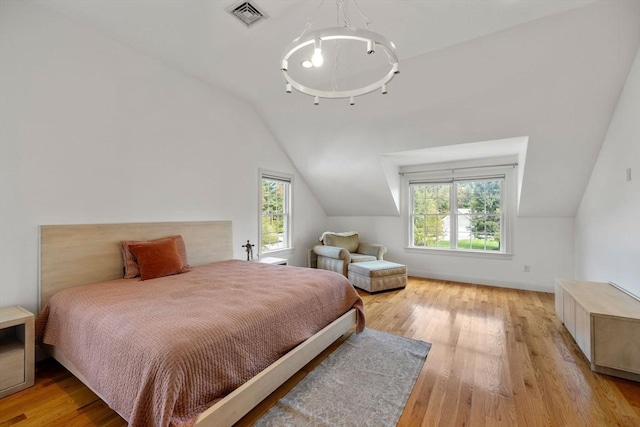 bedroom featuring multiple windows, light hardwood / wood-style floors, and lofted ceiling