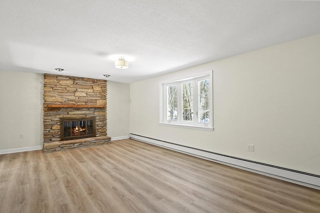 unfurnished living room with baseboards, a baseboard radiator, wood finished floors, a textured ceiling, and a fireplace