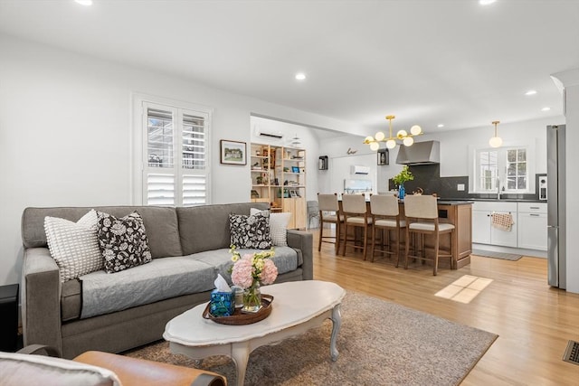 173 Liberty St, Braintree, MA 02184 - living area featuring light wood finished floors, recessed lighting, and a chandelier