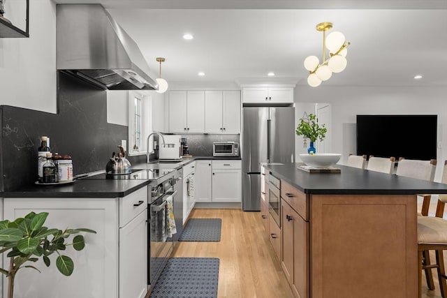 173 Liberty St, Braintree, MA 02184 - kitchen featuring extractor fan, stainless steel appliances, dark countertops, a breakfast bar area, and recessed lighting