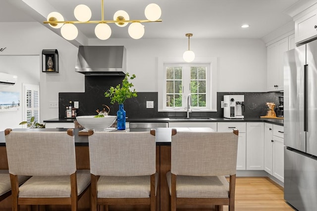 173 Liberty St, Braintree, MA 02184 - kitchen with freestanding refrigerator, wall chimney exhaust hood, dark countertops, a wall unit AC, and white cabinetry