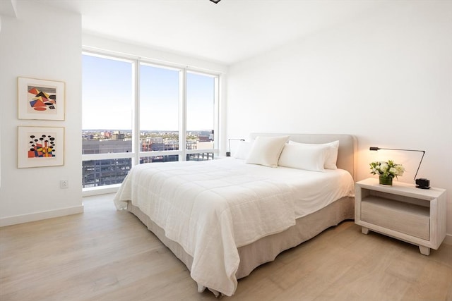 bedroom with light wood-style flooring and baseboards