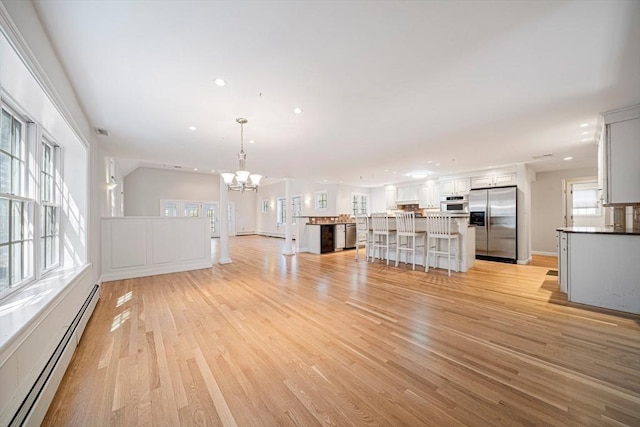 307 York St, Canton, MA 02021 - unfurnished living room with recessed lighting, a notable chandelier, light wood-type flooring, and a baseboard radiator