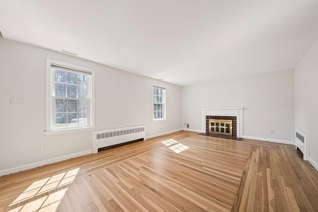 307 York St, Canton, MA 02021 - unfurnished living room featuring visible vents, baseboards, a brick fireplace, and radiator heating unit