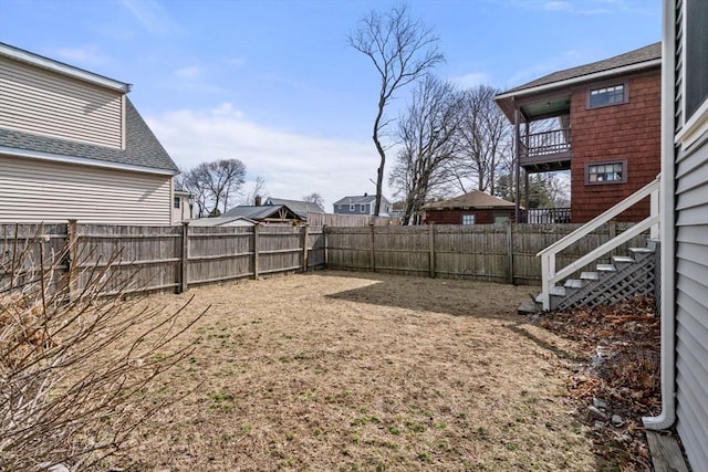 view of yard with a balcony and a fenced backyard