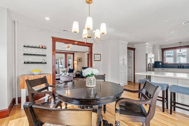 dining room with visible vents, light wood-type flooring, and baseboards