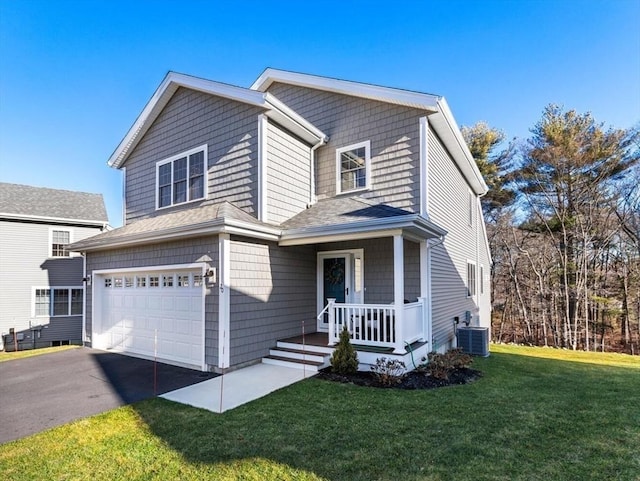 view of front property with a garage, a front lawn, and central air condition unit