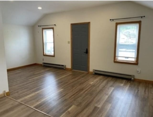 interior space featuring a baseboard radiator, lofted ceiling, and wood finished floors