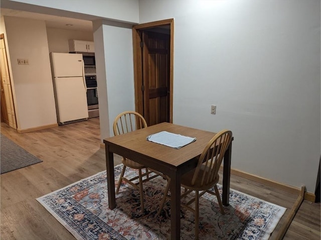 dining room with light wood-type flooring and baseboards