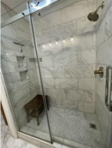 full bath featuring a marble finish shower