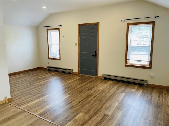 interior space with lofted ceiling, baseboards, baseboard heating, and wood finished floors