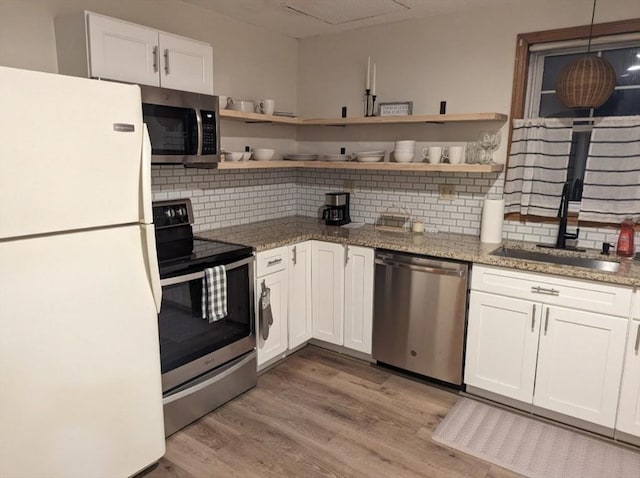 kitchen featuring light wood finished floors, white cabinetry, and appliances with stainless steel finishes