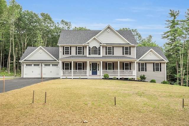 view of front of property with a front lawn, covered porch, and a garage