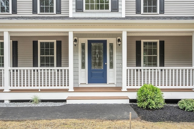 view of exterior entry featuring covered porch