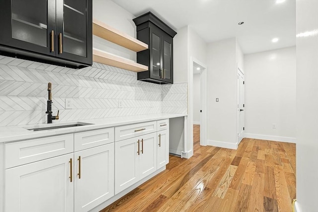 12 Martin St, Carlisle, MA 01741 - kitchen featuring decorative backsplash, light countertops, open shelves, glass insert cabinets, and recessed lighting