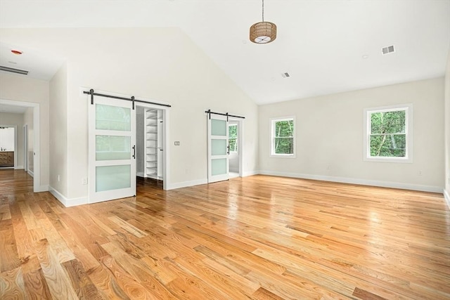 12 Martin St, Carlisle, MA 01741 - empty room with a barn door, high vaulted ceiling, and light wood-style floors