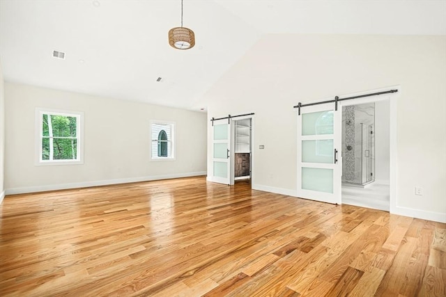 12 Martin St, Carlisle, MA 01741 - spare room with a barn door, high vaulted ceiling, healthy amount of natural light, and light wood finished floors