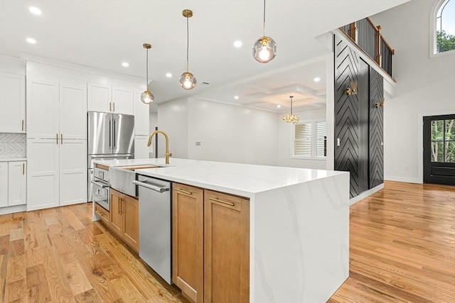 12 Martin St, Carlisle, MA 01741 - kitchen featuring appliances with stainless steel finishes, recessed lighting, light wood-type flooring, a kitchen island with sink, and white cabinets