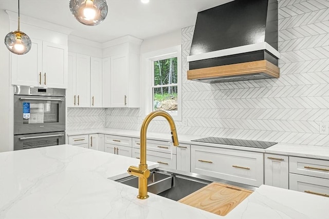 12 Martin St, Carlisle, MA 01741 - kitchen featuring premium range hood, double oven, black electric cooktop, tasteful backsplash, and white cabinetry