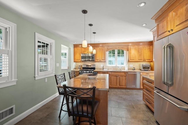16 Bailey Ln, Dedham, MA 02026 - kitchen with appliances with stainless steel finishes, a kitchen breakfast bar, a sink, tasteful backsplash, and pendant lighting