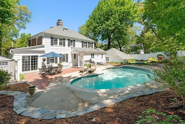 16 Bailey Ln, Dedham, MA 02026 - back of house with a patio area, a fenced backyard, a chimney, roof with shingles, and outdoor dining space
