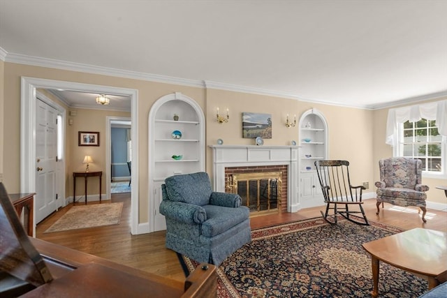 16 Bailey Ln, Dedham, MA 02026 - living area with wood finished floors, built in shelves, a brick fireplace, ornamental molding, and baseboards