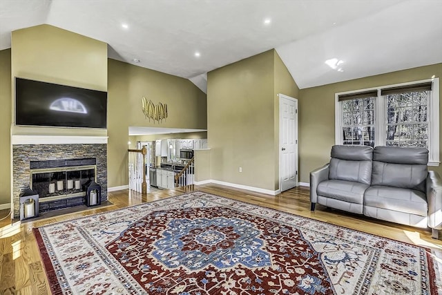 56 Ireta Rd, Shrewsbury, MA 01545 - living room with vaulted ceiling, baseboards, wood finished floors, a fireplace, and recessed lighting