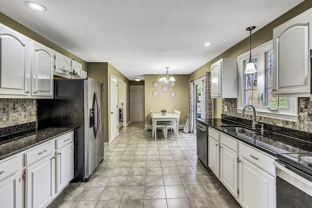 56 Ireta Rd, Shrewsbury, MA 01545 - kitchen with a sink, appliances with stainless steel finishes, a chandelier, white cabinetry, and decorative backsplash