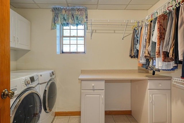 laundry area featuring cabinets, light tile patterned floors, and washer and dryer