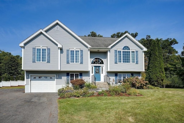 bi-level home with a garage and a front yard