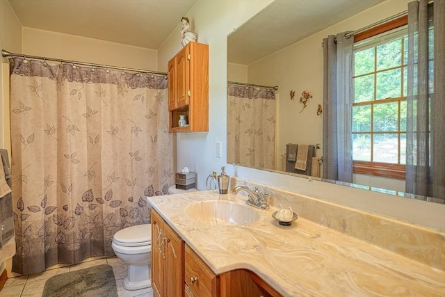 bathroom with toilet, vanity, and tile patterned floors