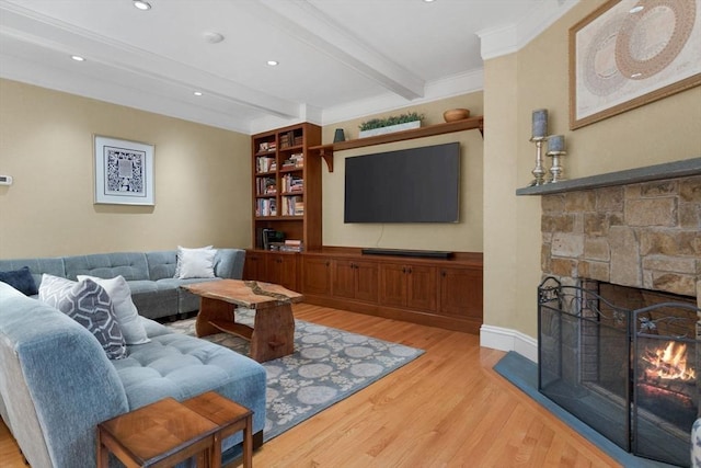 living room with crown molding, beam ceiling, recessed lighting, a fireplace, and light wood-style floors