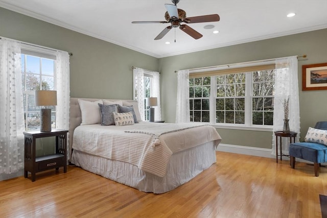 bedroom with crown molding, multiple windows, and wood finished floors