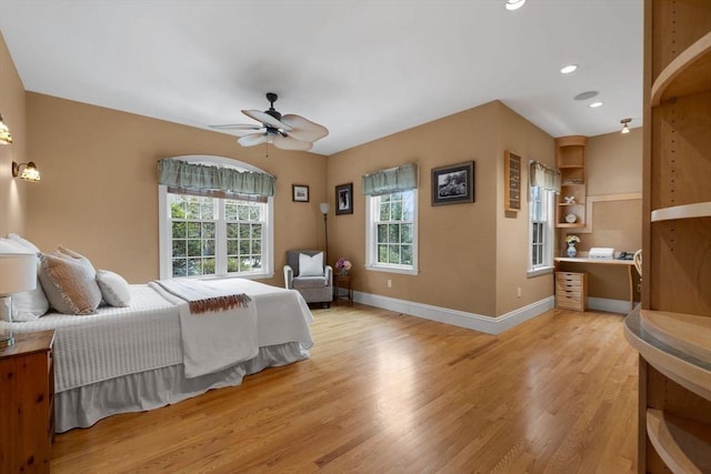 bedroom with light wood finished floors, recessed lighting, multiple windows, and baseboards