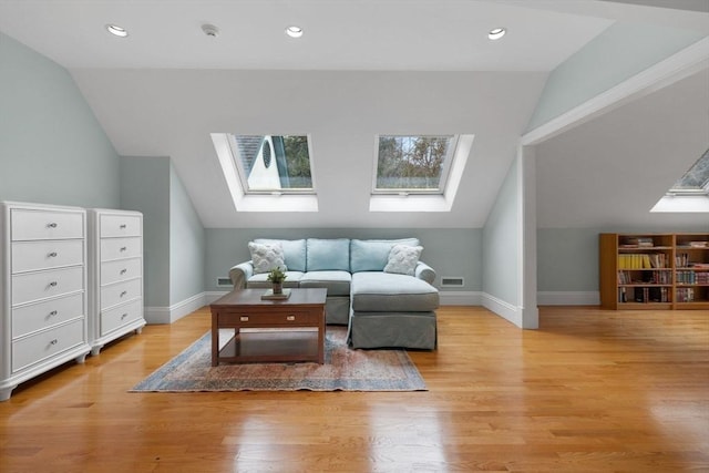 interior space with visible vents, baseboards, vaulted ceiling with skylight, light wood-style flooring, and recessed lighting