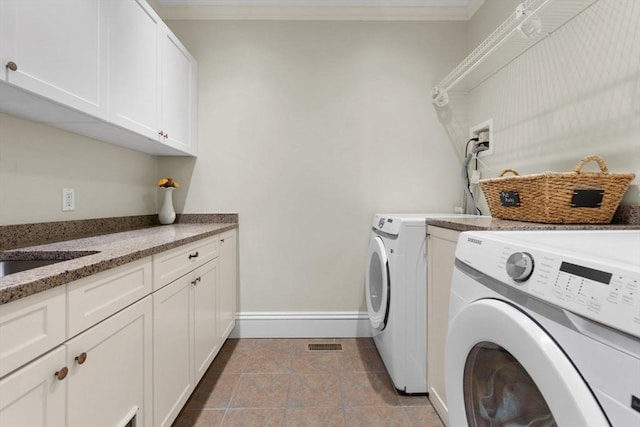 washroom featuring tile patterned flooring, cabinet space, washer and dryer, and crown molding