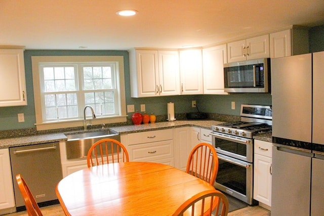 kitchen with sink, white cabinetry, and stainless steel appliances