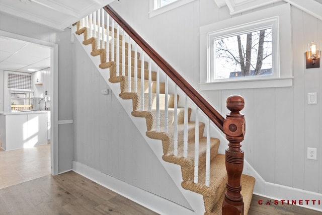 stairs featuring hardwood / wood-style flooring and sink