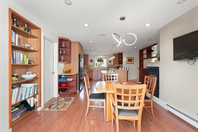 dining room featuring recessed lighting, baseboard heating, and light wood-style flooring